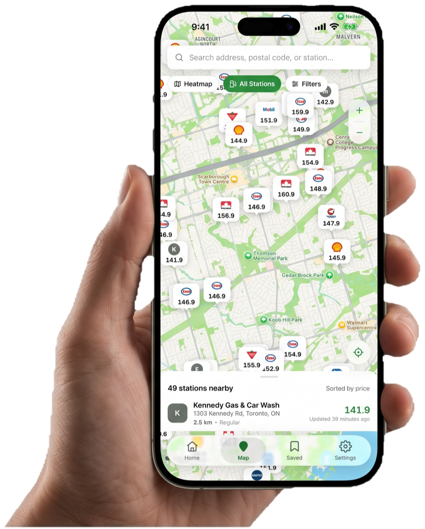 A hand holding a phone running GasMap, with live station prices on the map